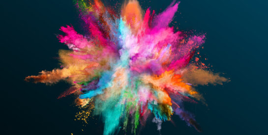 Powder explosion of color on black background. Freeze motion.